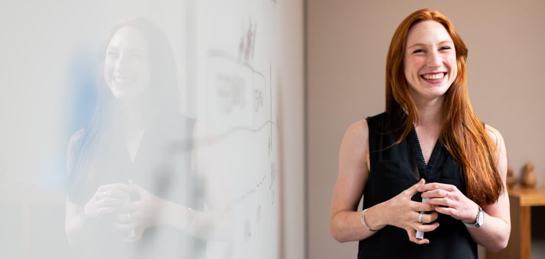 Woman talking infront of a white board.